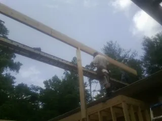 Carpenter setting a ridge beam over a new addition frame — Ice Dam Removal by Roofing Brothers in Ringoes