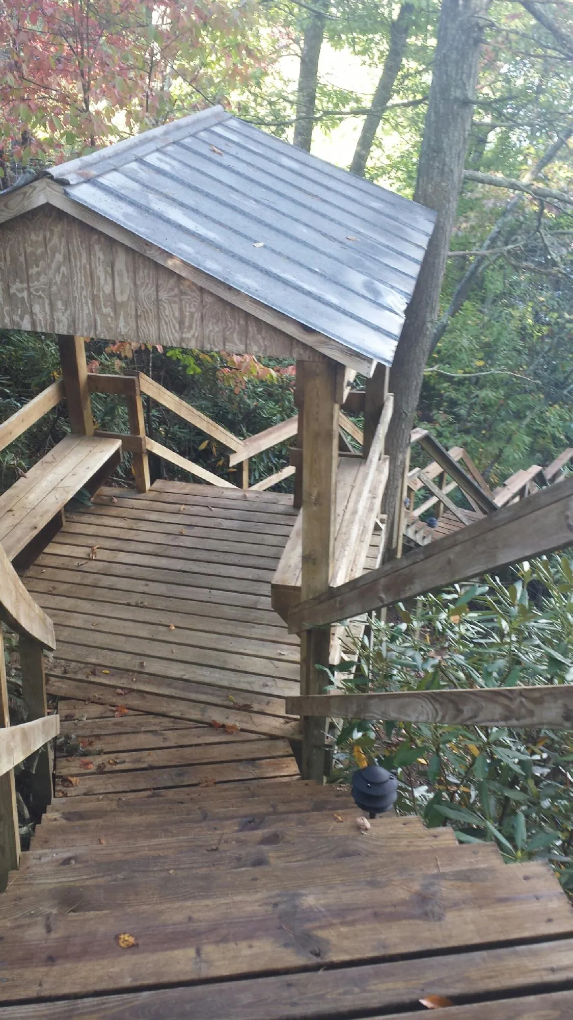 Metal roofed shelter over wooden steps on a wooded walkway — Skylight Repair & Installation work by our crew in Ringoes