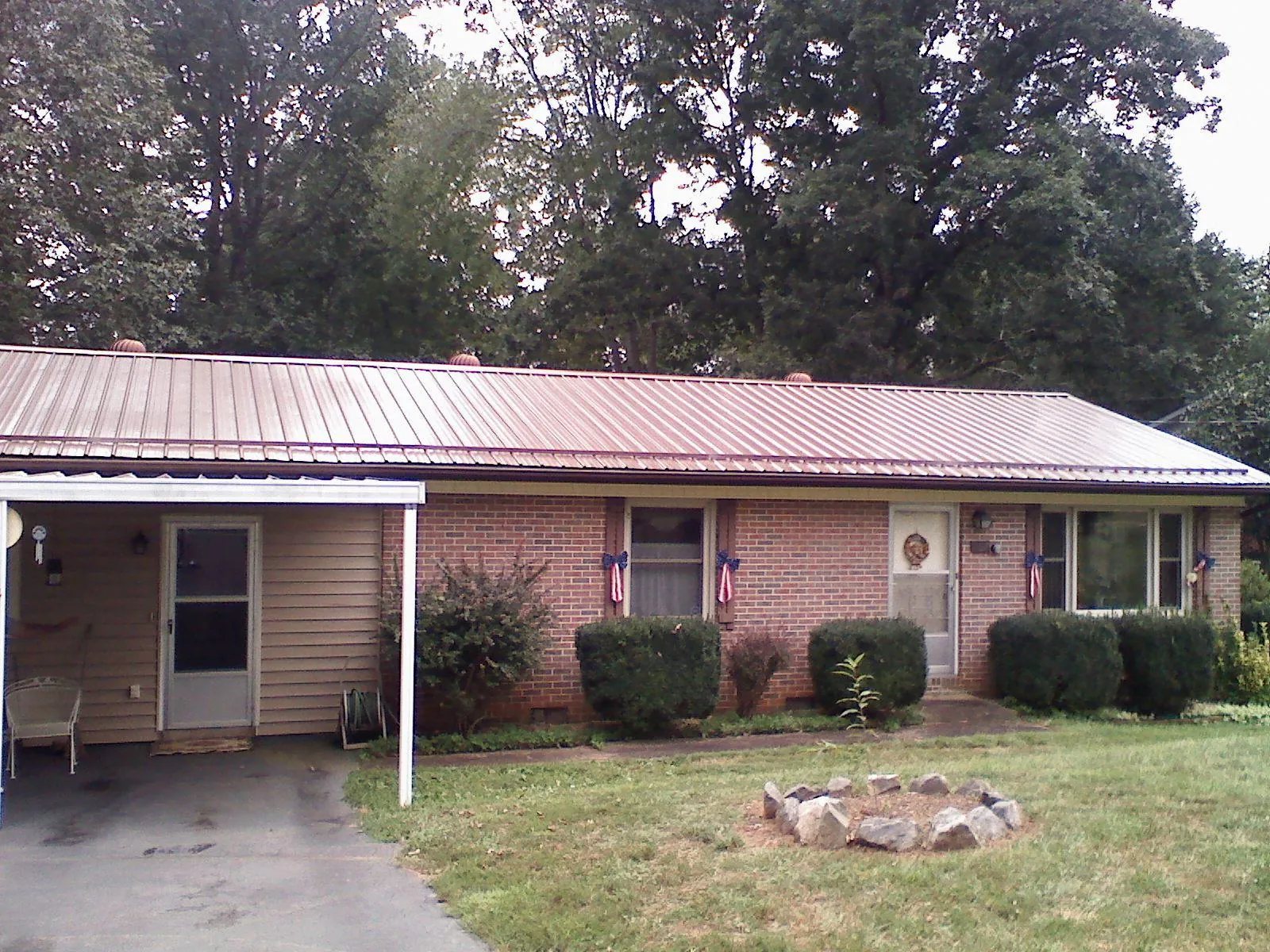 Bronze metal roof and carport on a brick ranch home — Roof Repair work by our crew in Ringoes